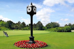 Clock tower on the golf course surrounded by flowers